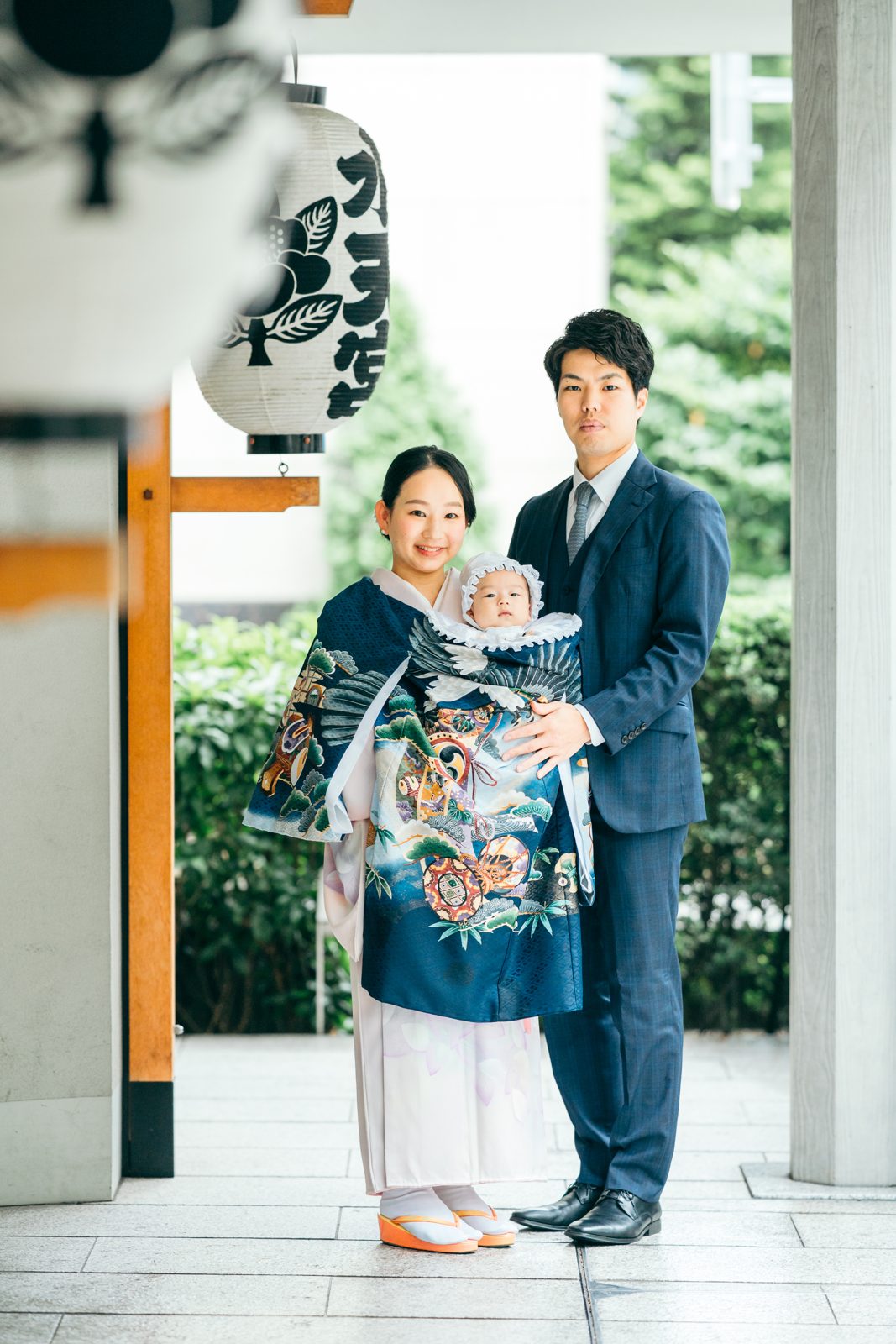 水天宮の参道で、お宮参りの晴れ着姿の赤ちゃんを抱くご夫婦