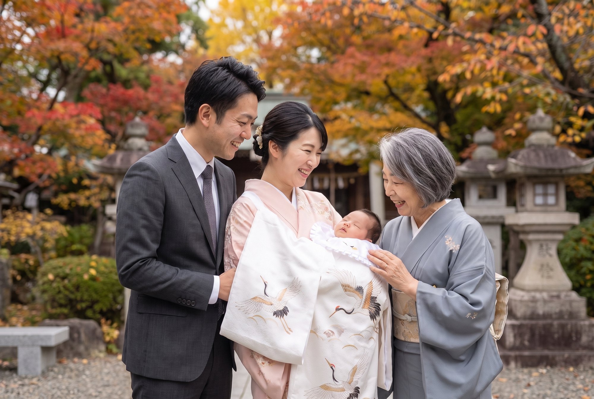 両親と祖母が、晴れ着に包まれた赤ちゃんを囲んで笑う